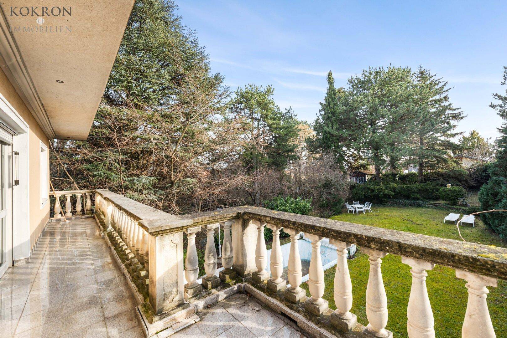 Geräumiger Balkon mit Balustrade, Blick auf den Garten und den Swimmingpool.