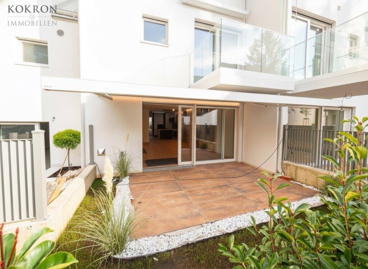Erdgeschoss-Terrasse mit kleinem Gartenbereich und direktem Zugang zum Wohnraum.