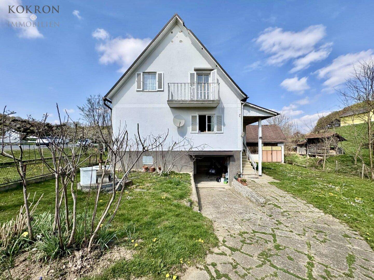 Vorderansicht des Einfamilienhauses mit integrierter Garage und Zufahrt auf dem Grundstück.