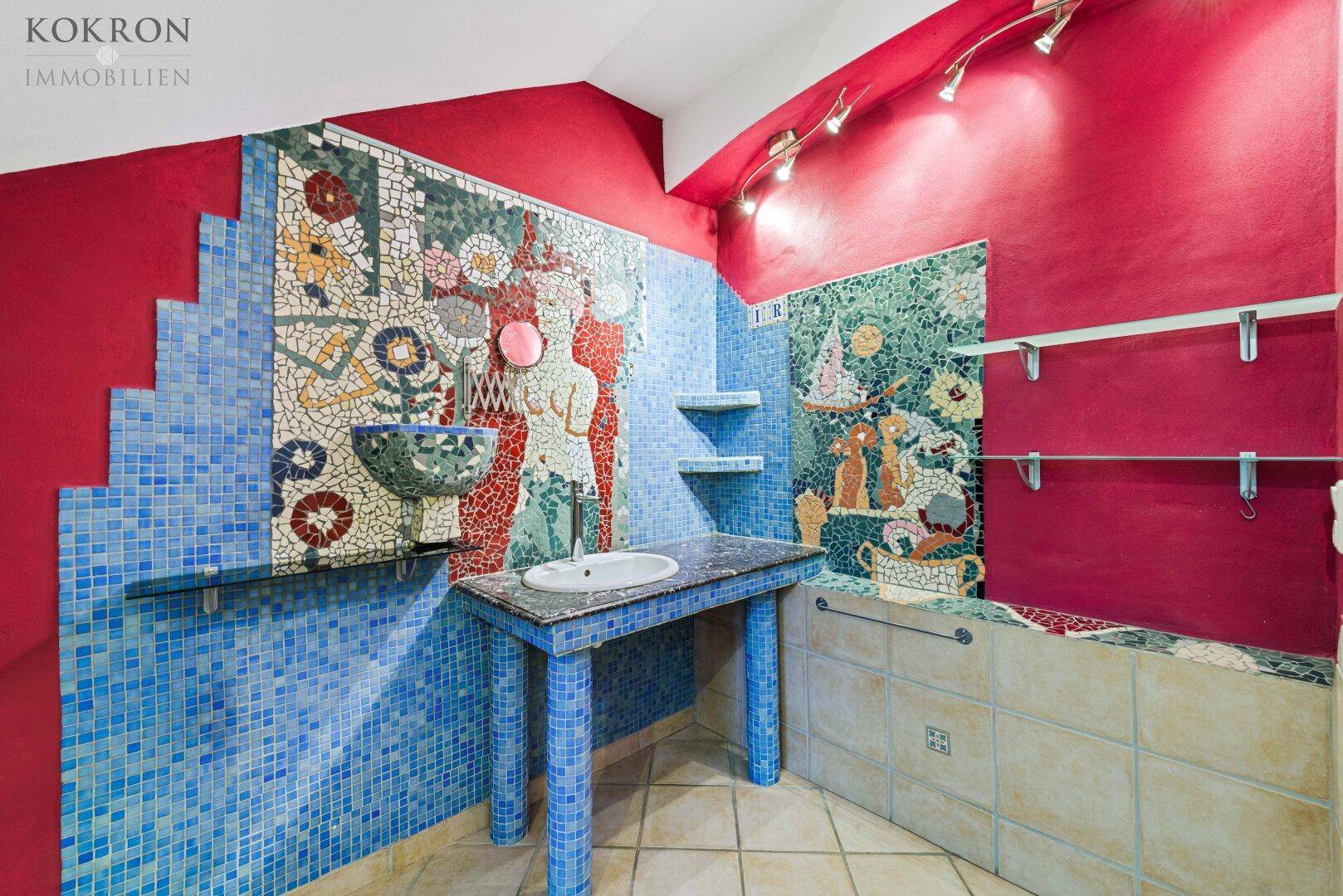 Einzigartiges Badezimmer mit farbenfrohen Mosaikfliesen und künstlerischem Design.