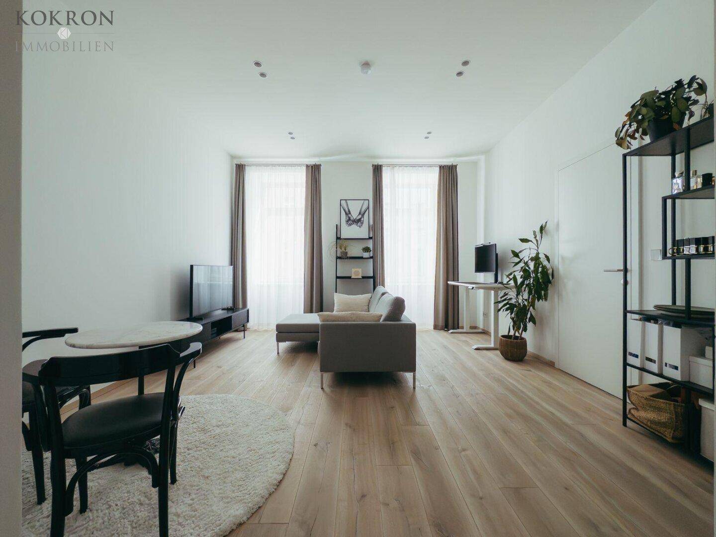 Geräumiger Wohn- und Essbereich mit Holzboden, modernem Sofa und Esstisch.