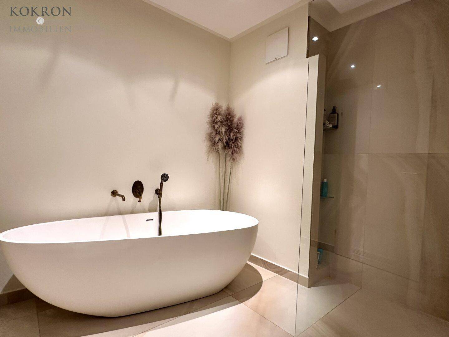 Modernes Badezimmer mit freistehender Badewanne und geräumiger begehbarer Dusche.