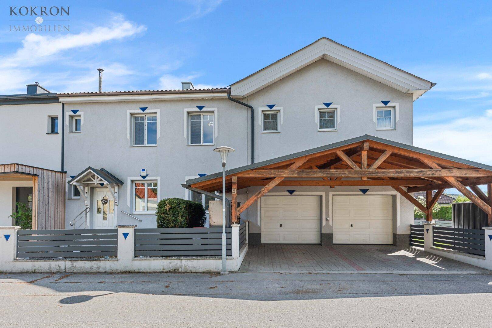 Ansicht des Hauses von der Seite mit Doppelgarage, Carport und gepflegter Zufahrt.