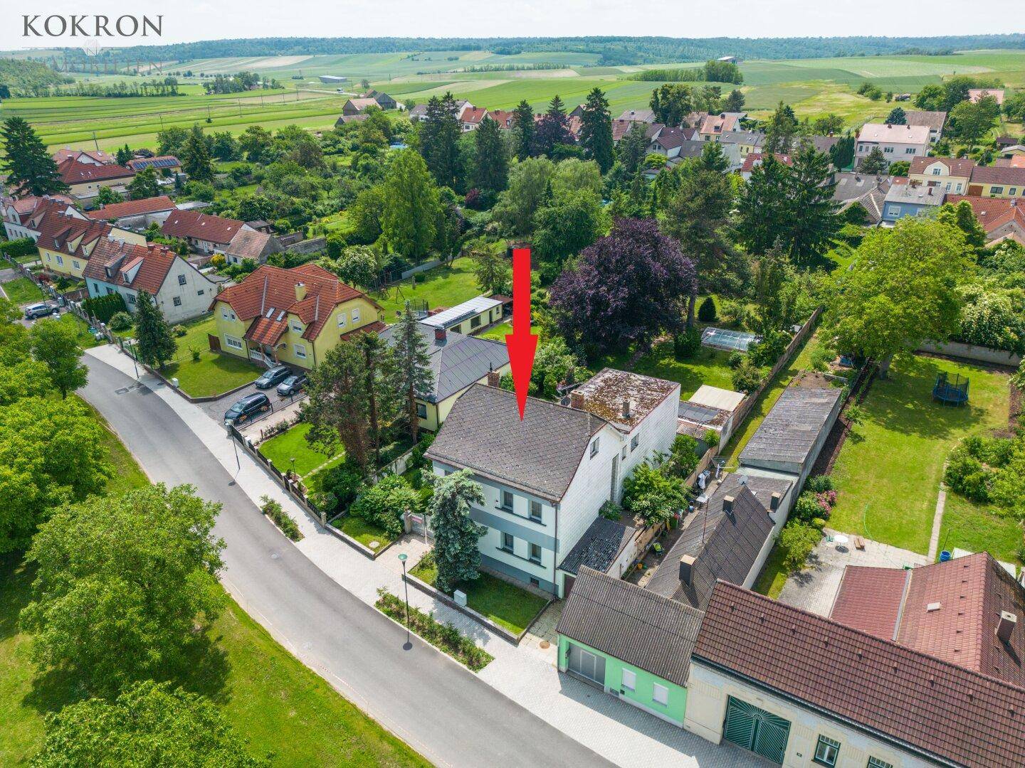 Luftaufnahme eines Wohnhauses in ländlicher Umgebung mit umliegenden Feldern und Häusern.