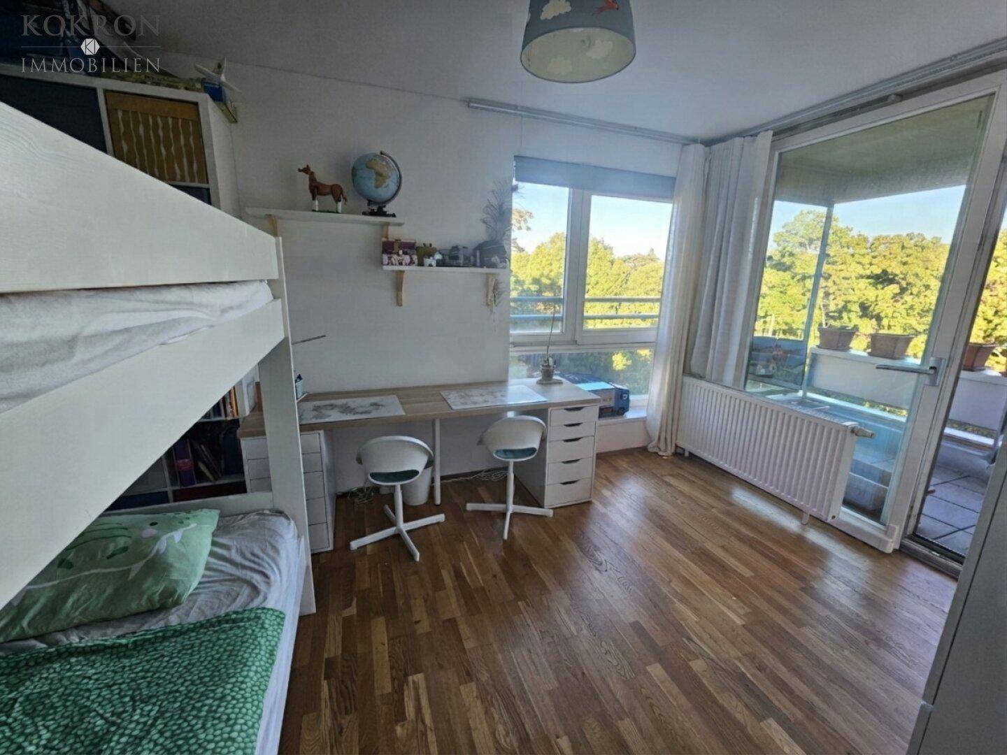 Kinderzimmer mit Etagenbett, Schreibtisch und direktem Zugang zum sonnigen Balkon, sehr hell.