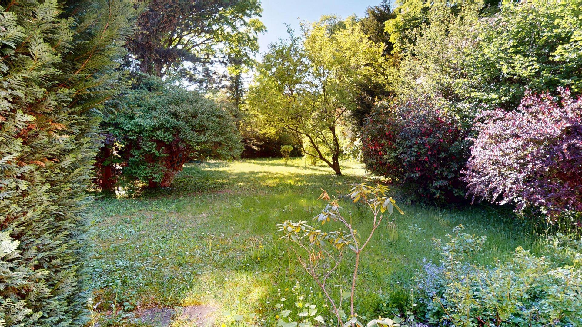 Großer, gepflegter Garten mit altem Baumbestand und viel Grünfläche, ideal zum Entspannen und Spielen.