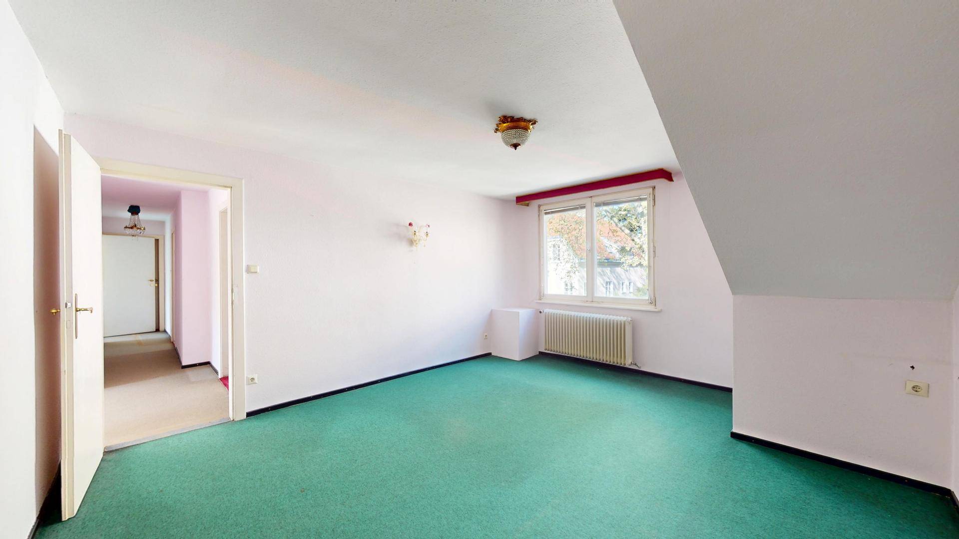 Helles Zimmer mit Teppichboden und Dachschräge, bietet vielseitige Nutzungsmöglichkeiten in ruhiger Lage.