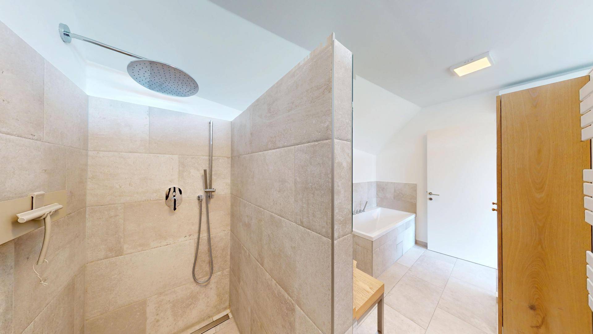 Elegantes Badezimmer mit großer begehbarer Dusche, Regendusche und hellen Fliesen in Natursteinoptik.