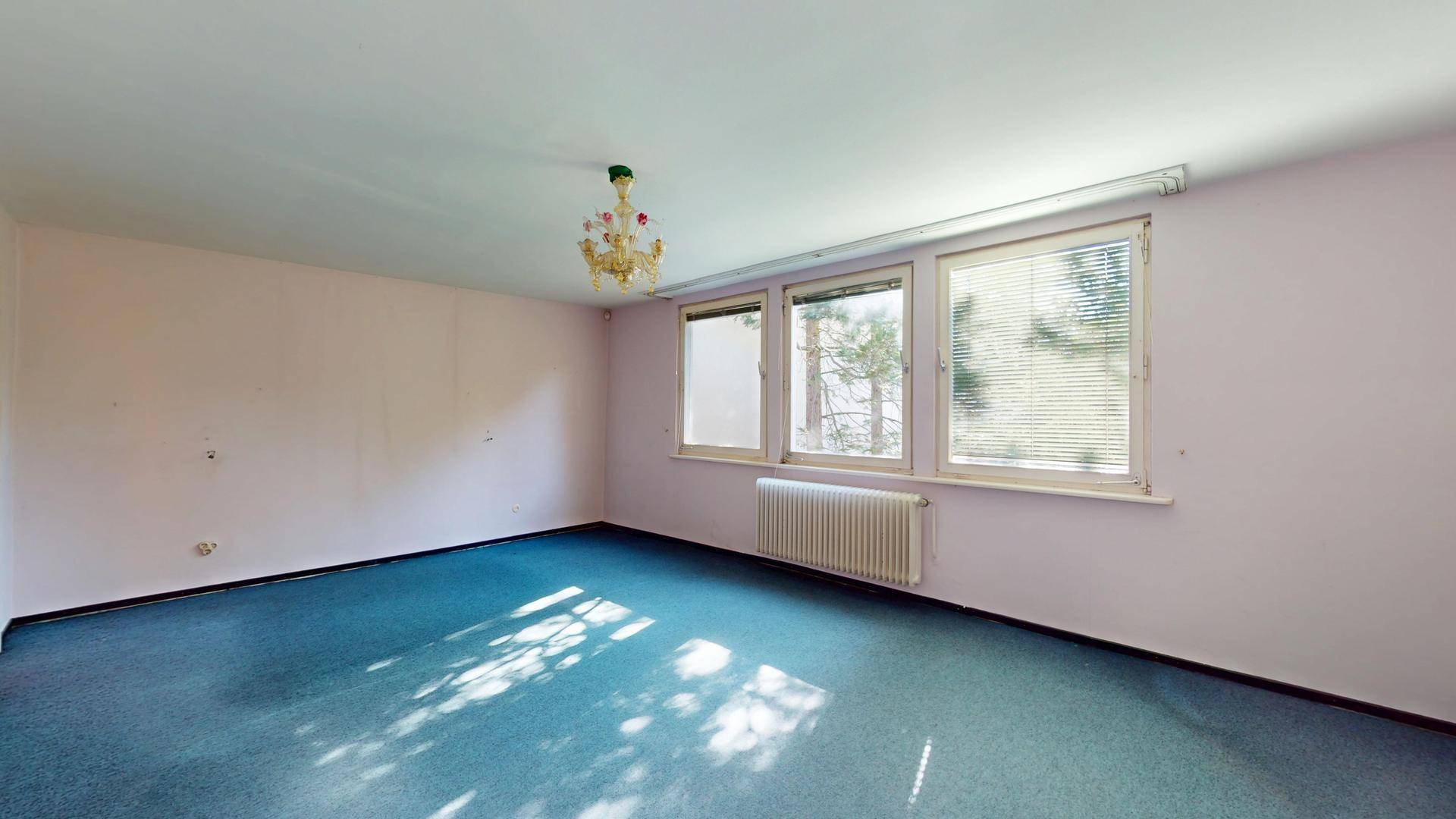 Geräumiges Schlafzimmer mit Teppichboden und großen Fenstern, bietet viel Potenzial für eine individuelle Einrichtung.