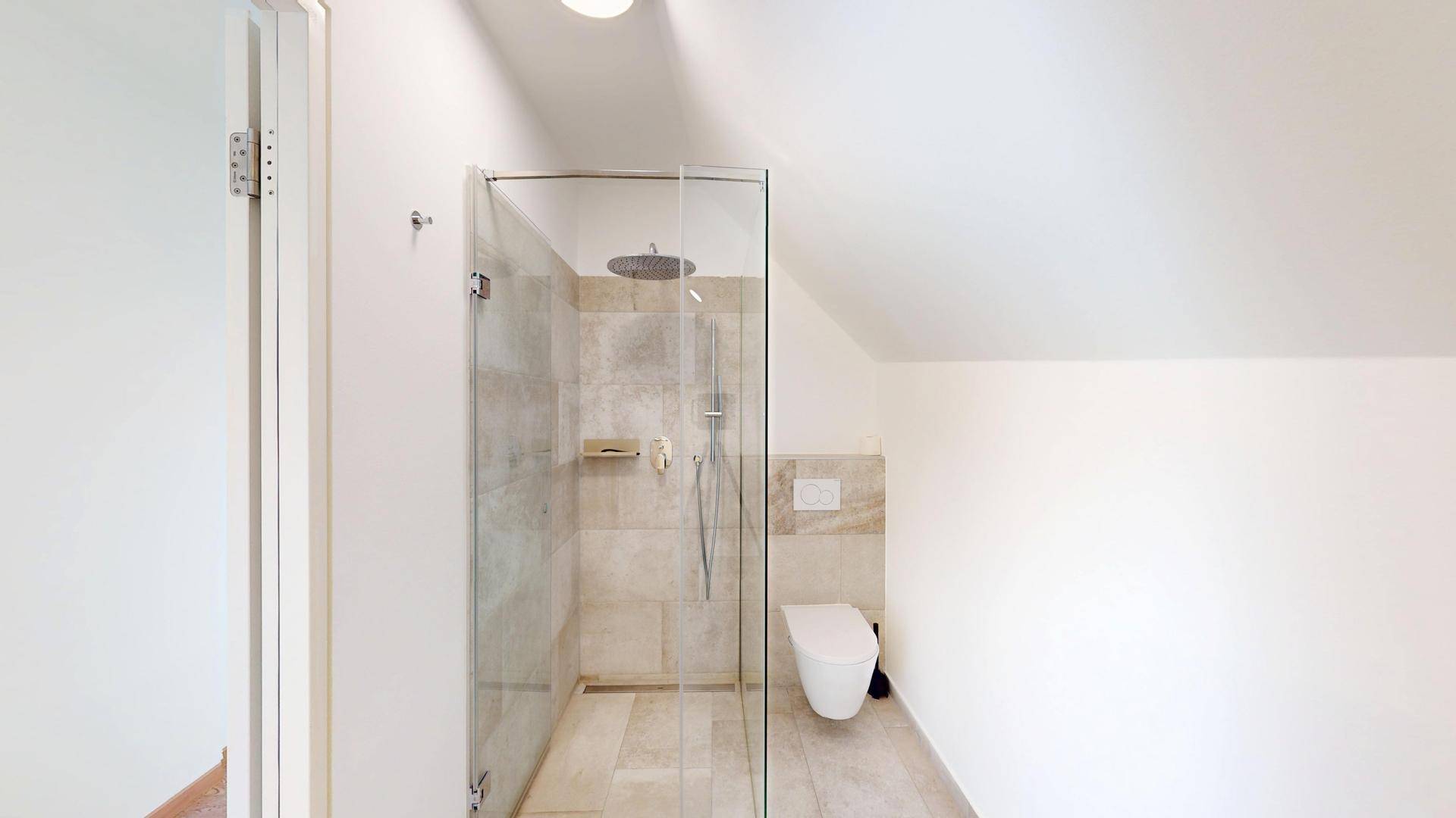 Modernes Badezimmer mit begehbarer Dusche, wandhängendem WC und hellen Fliesen in Natursteinoptik.
