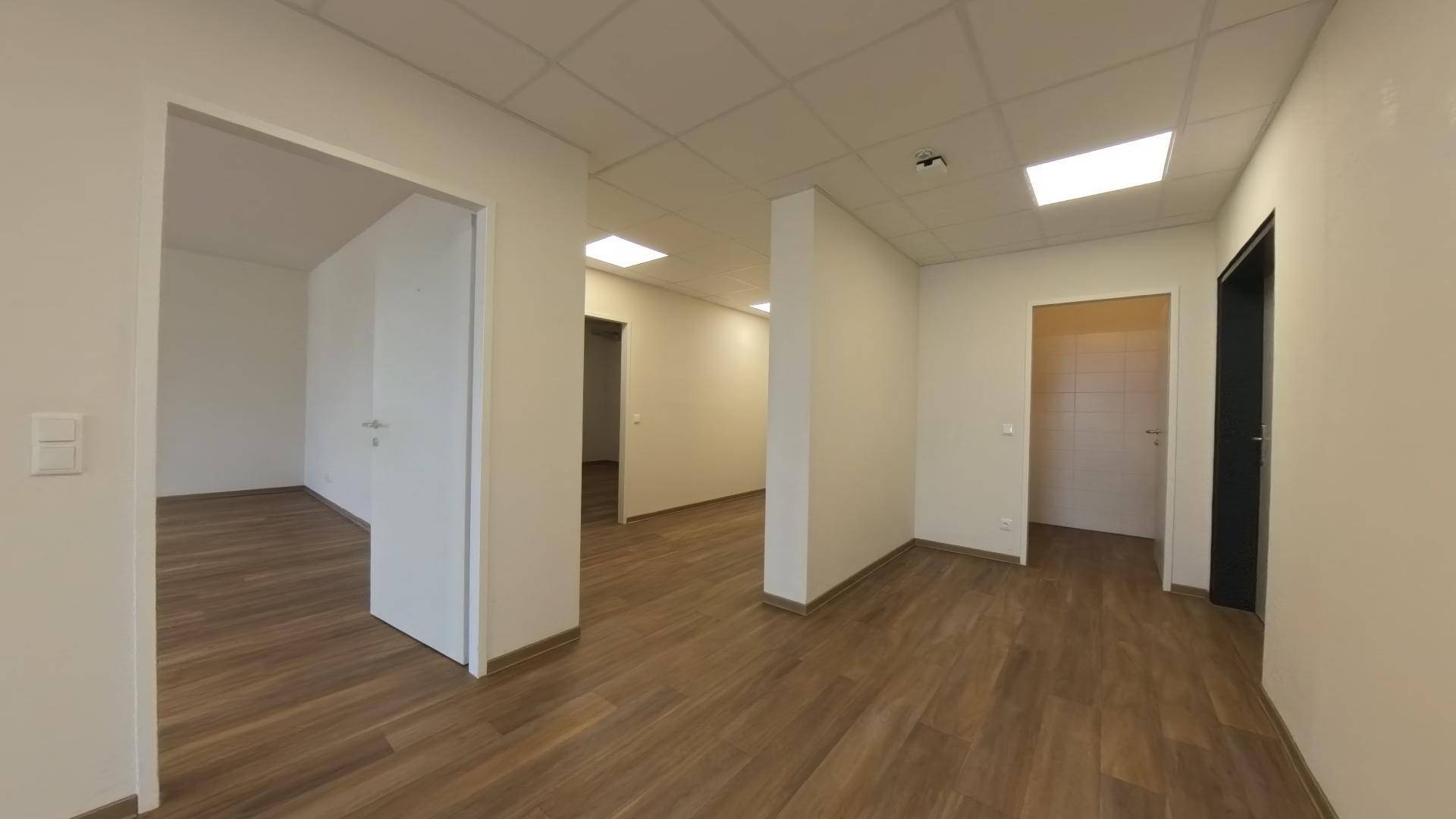 Heller Flur mit Laminatboden und mehreren Türen, der zu verschiedenen Büroräumen führt.