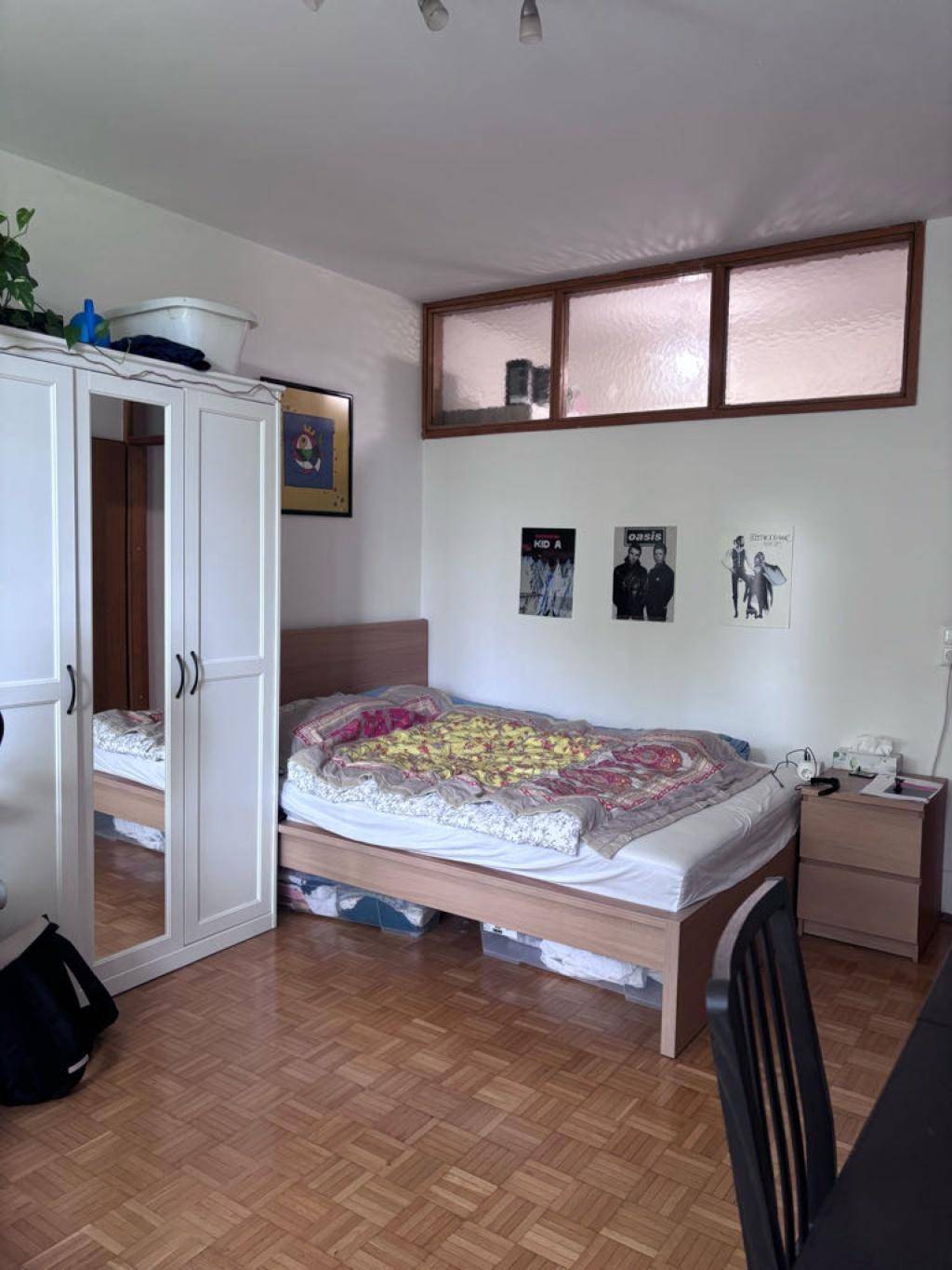 Gemütliches Schlafzimmer mit Parkettboden, Bett und Kleiderschrank, gut beleuchtet.