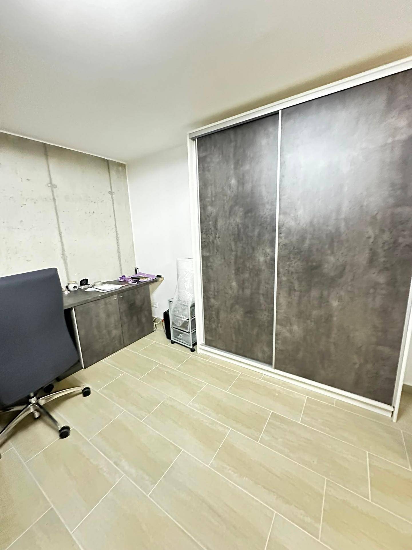 Helles Arbeitszimmer mit großem Schiebetürenschrank und modernem Bodenbelag.