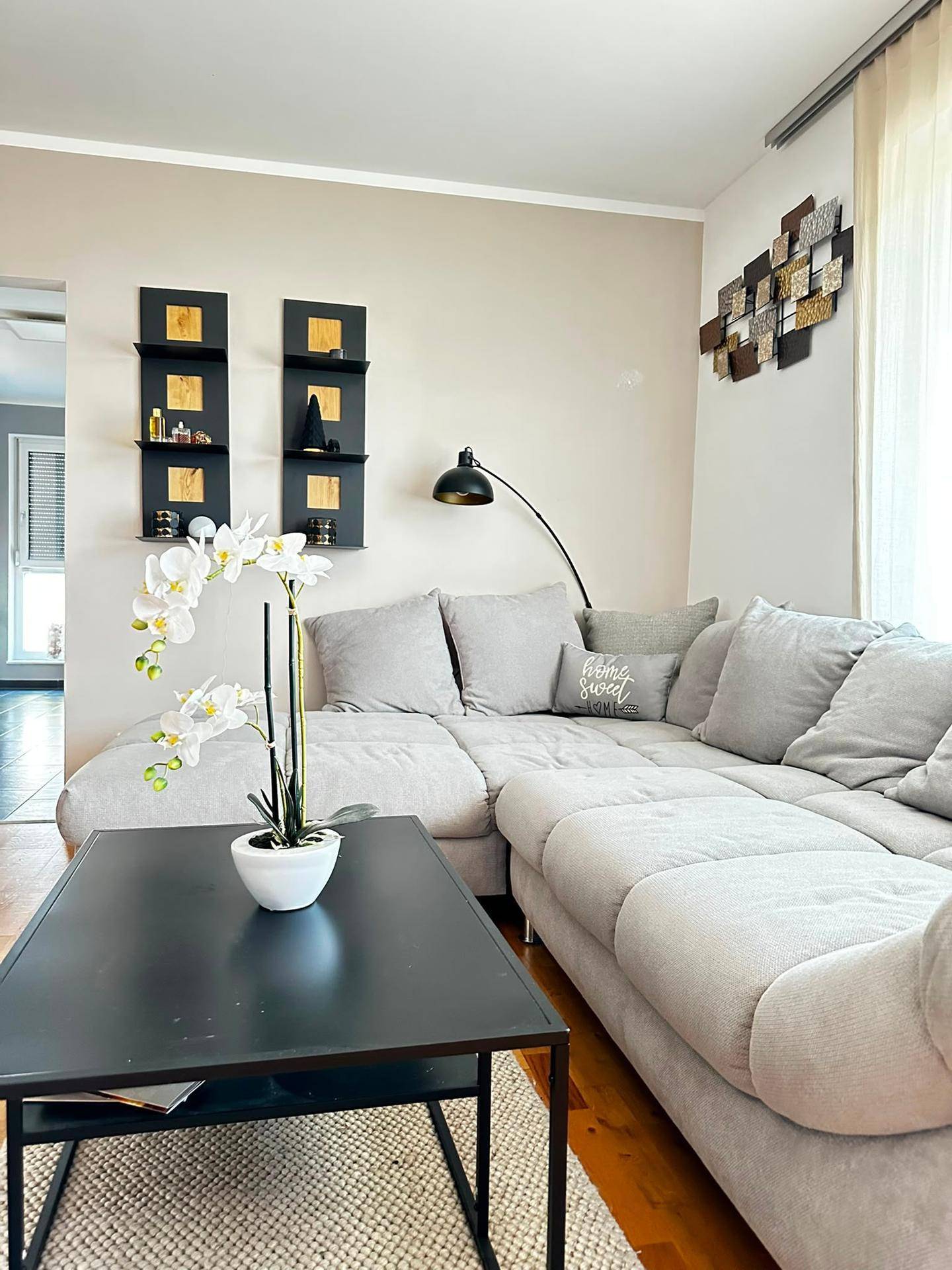 Gemütliches Wohnzimmer mit großem Ecksofa, Couchtisch und moderner Dekoration.