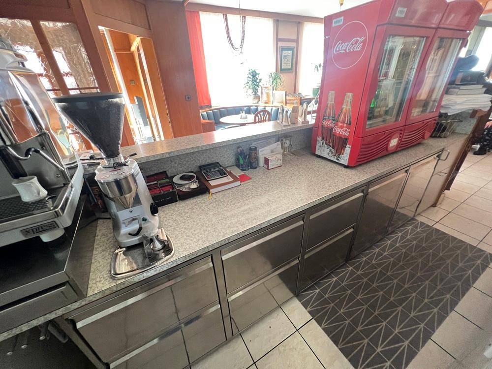 Funktionaler Servicebereich mit Kaffeemaschine, Getränkekühlschrank und robuster Arbeitsplatte.