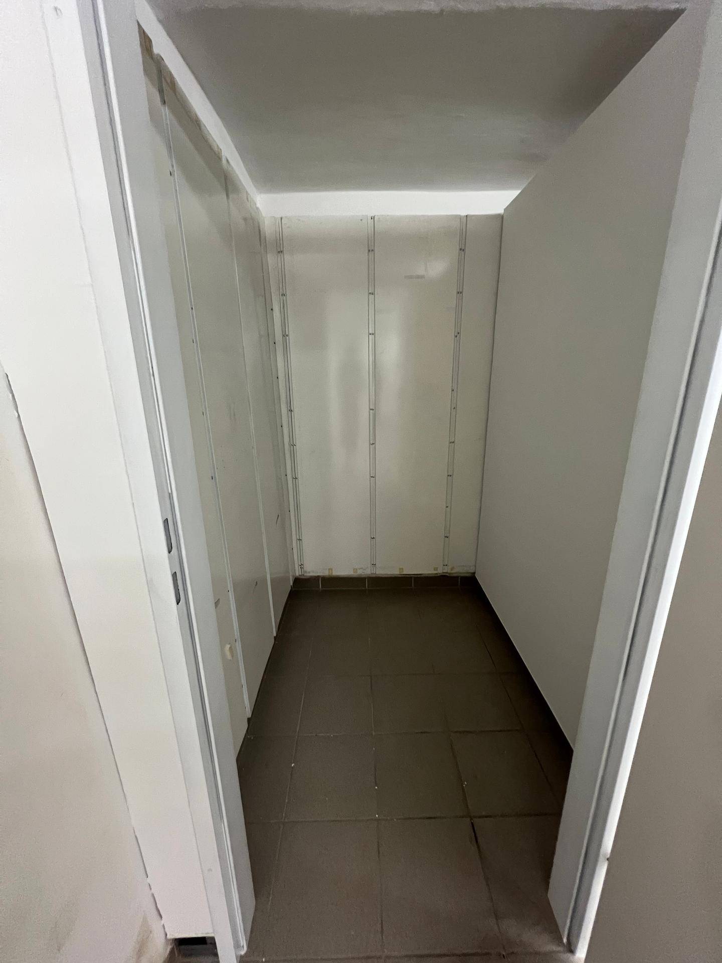 Innenansicht eines leeren, sehr sauberen Lagerabteils mit Fliesenboden, bereit zur Nutzung.