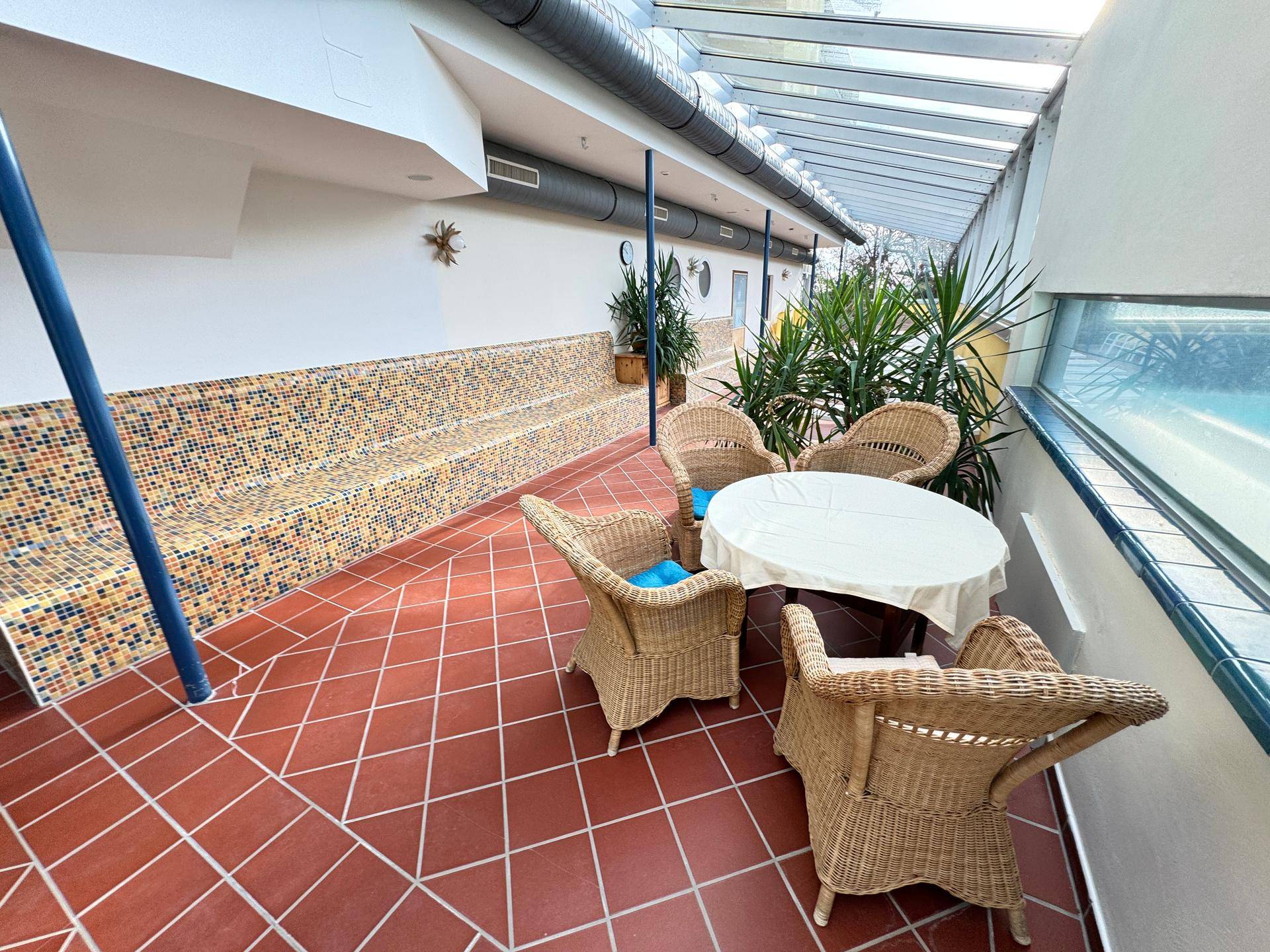 Innenpoolbereich mit Sitzgelegenheiten und Blick auf den Pool.