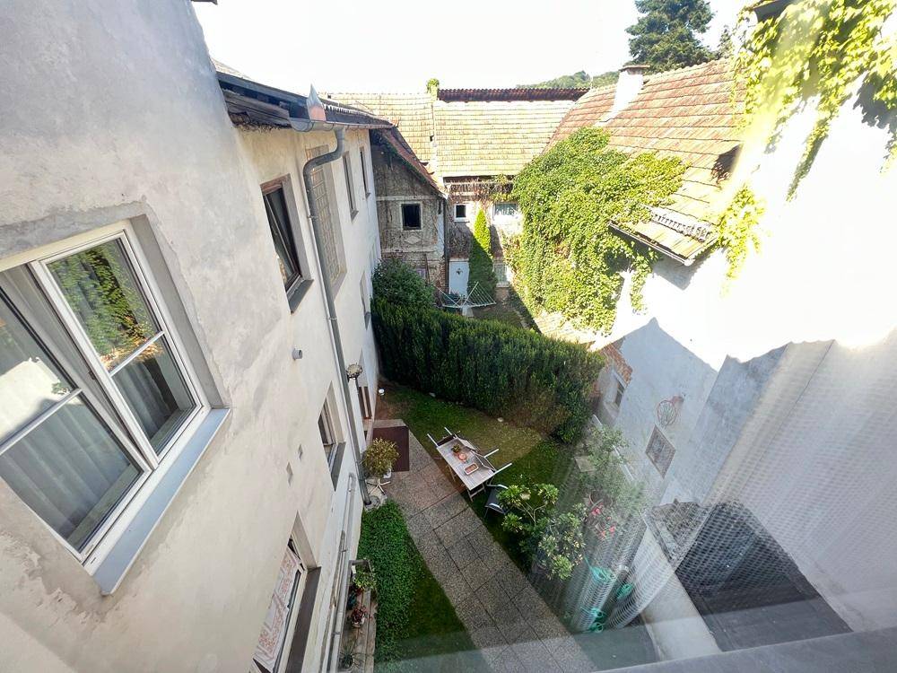 Innenhof mit Grünflächen, Hecken und Blick auf die umliegenden Gebäude.