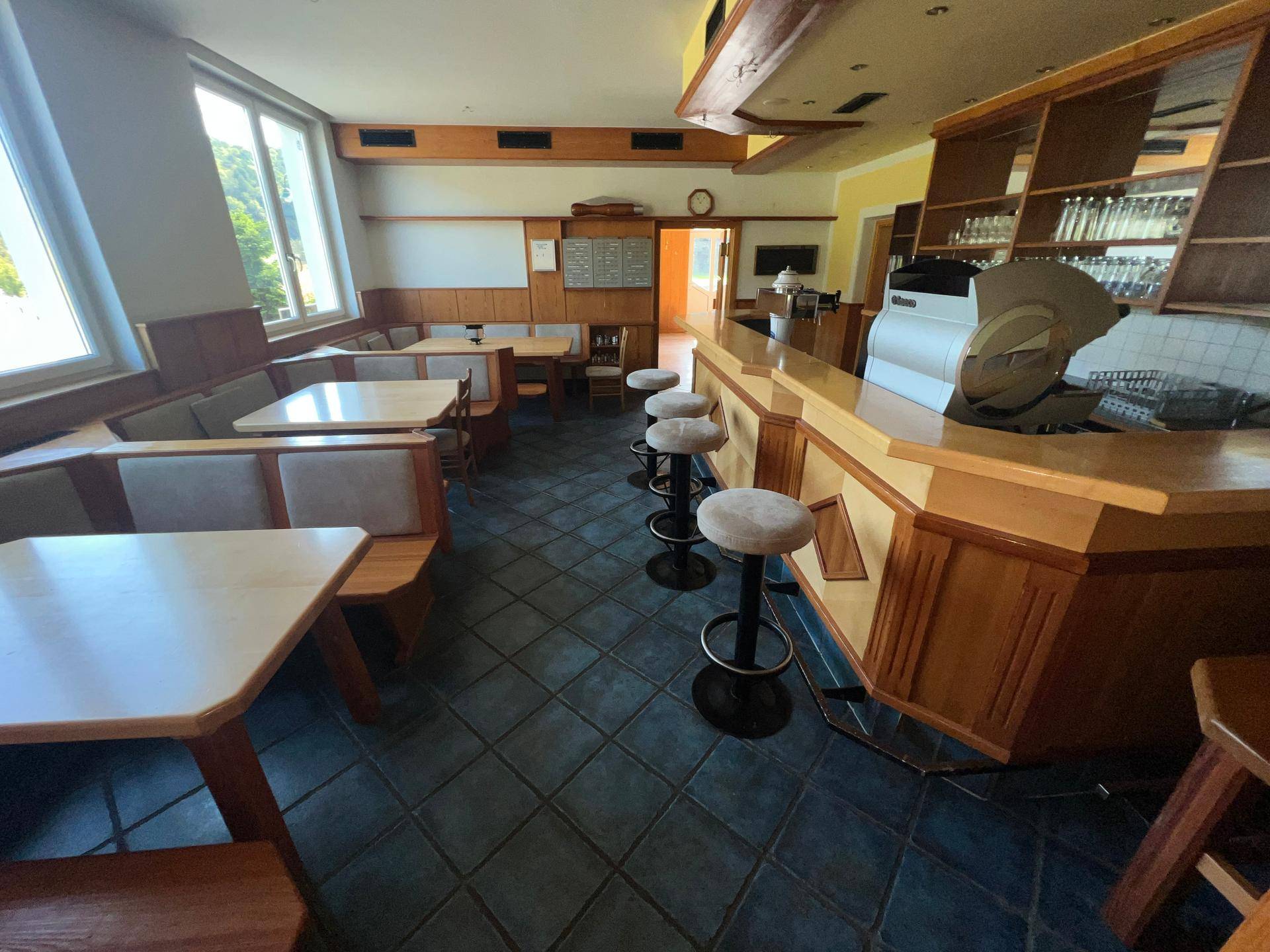 Gemütlicher Barbereich mit Holztischen, Bänken und Barhockern, ideal für gesellige Runden.