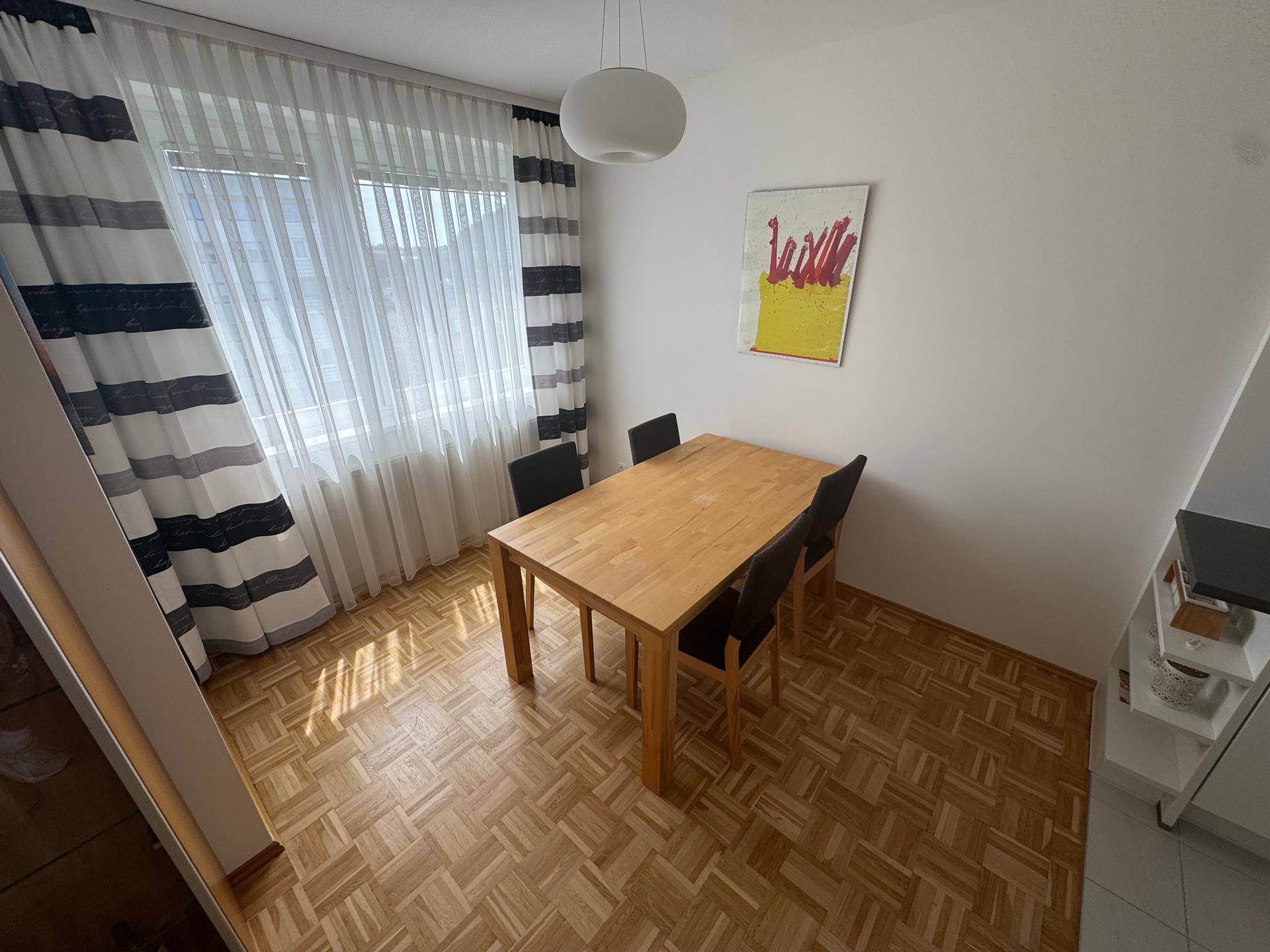 Essbereich mit Holztisch und Stühlen, offen zur Küche, mit viel Tageslicht.