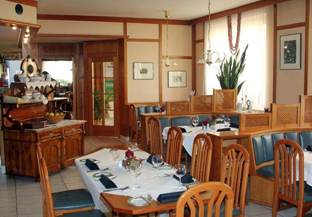 Gemütlicher Essbereich mit Holztischen, Bänken und traditioneller Einrichtung.