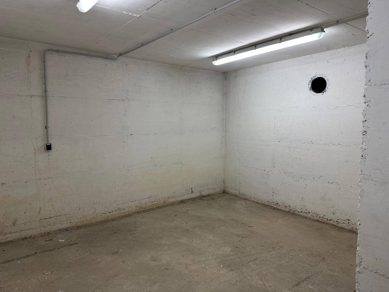 Leerer Lagerraum im Keller mit Betonwänden und -boden.