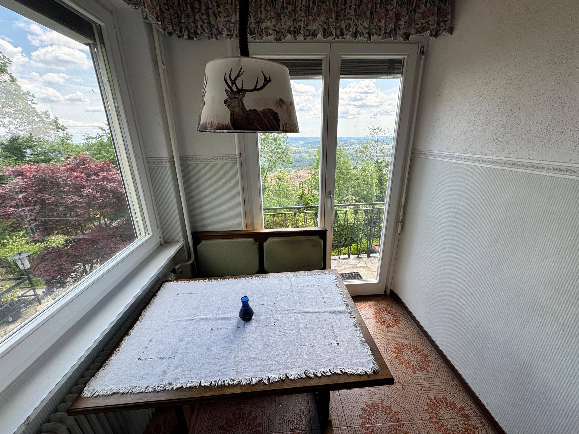 Gemütlicher Essbereich mit traditionellem Tisch und Stühlen, bietet einen weiten Blick ins Grüne.