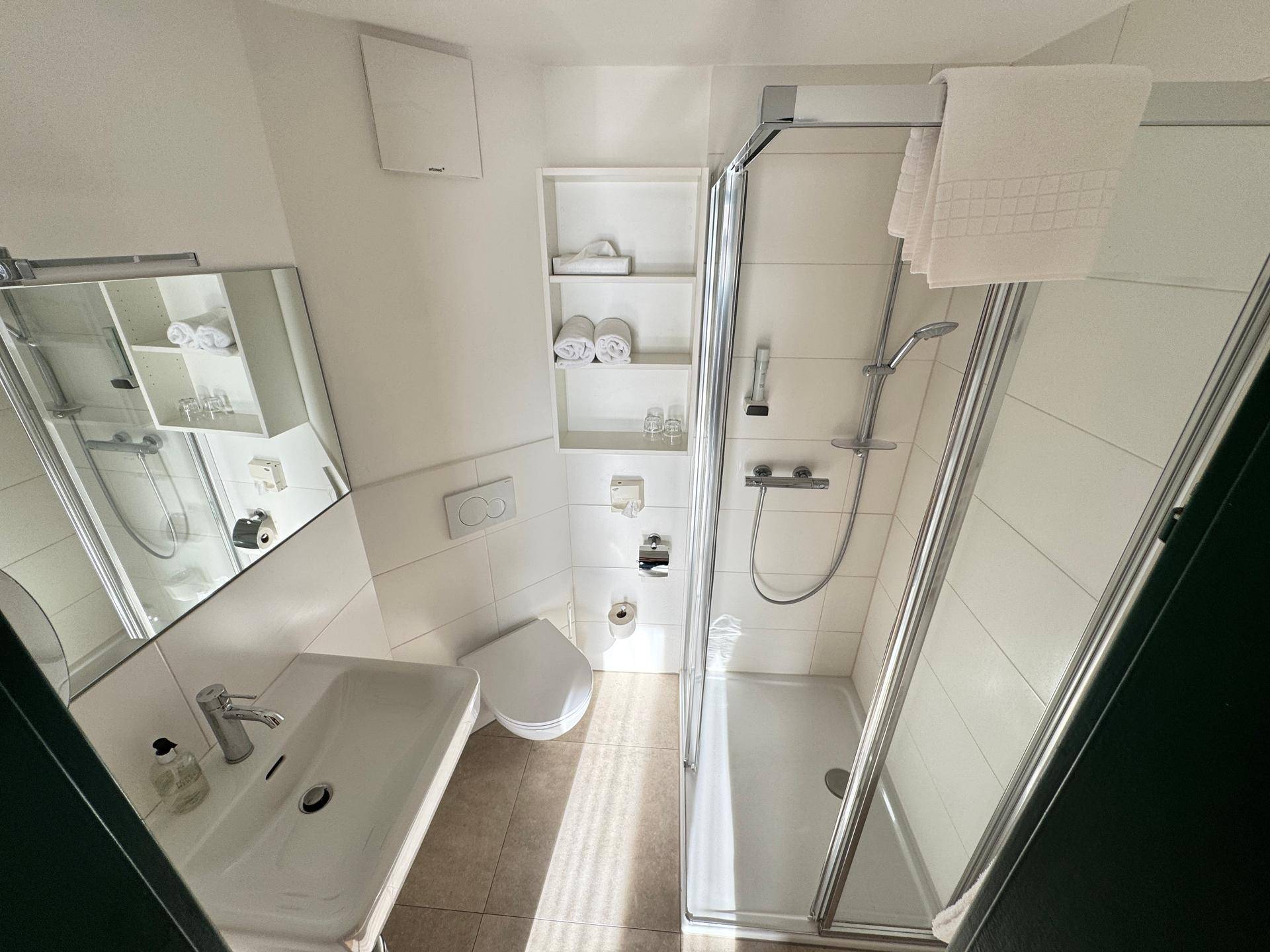 Badezimmer mit Duschkabine, Waschbecken und WC.