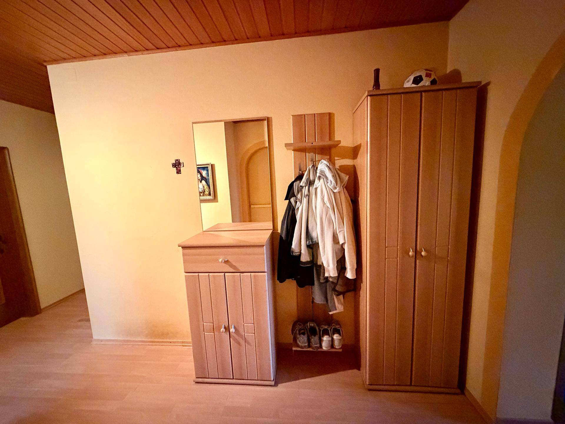 Flur mit Holzmöbeln, Spiegel und Garderobe, bietet Stauraum und Empfang.