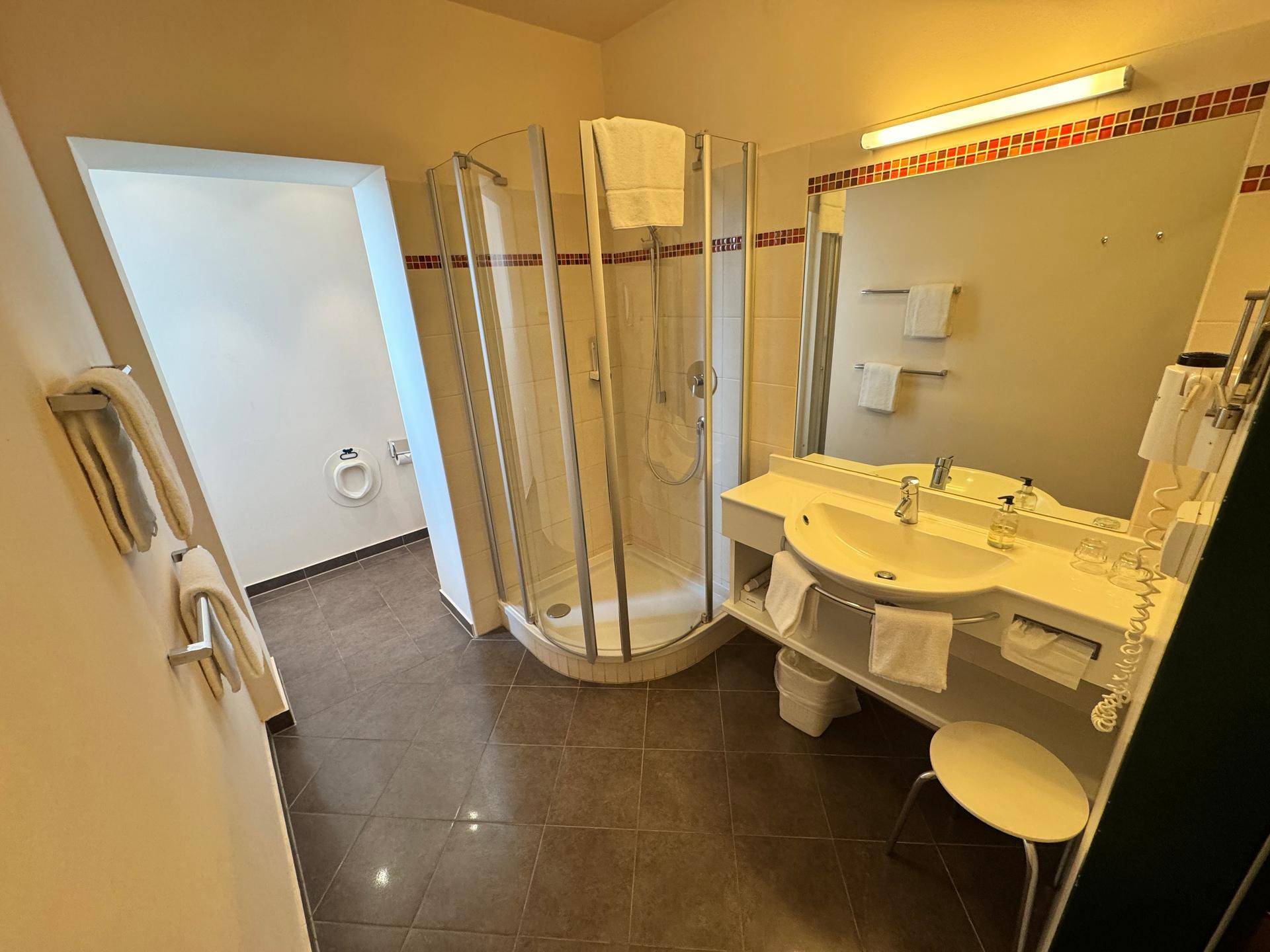 Badezimmer mit Duschkabine, Waschbecken und WC.