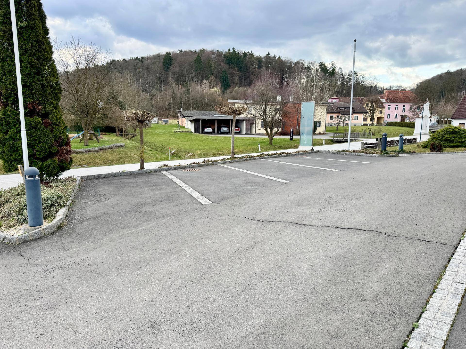 Parkplatz mit Blick auf die ländliche Umgebung und das gelbe Gebäude im Hintergrund.