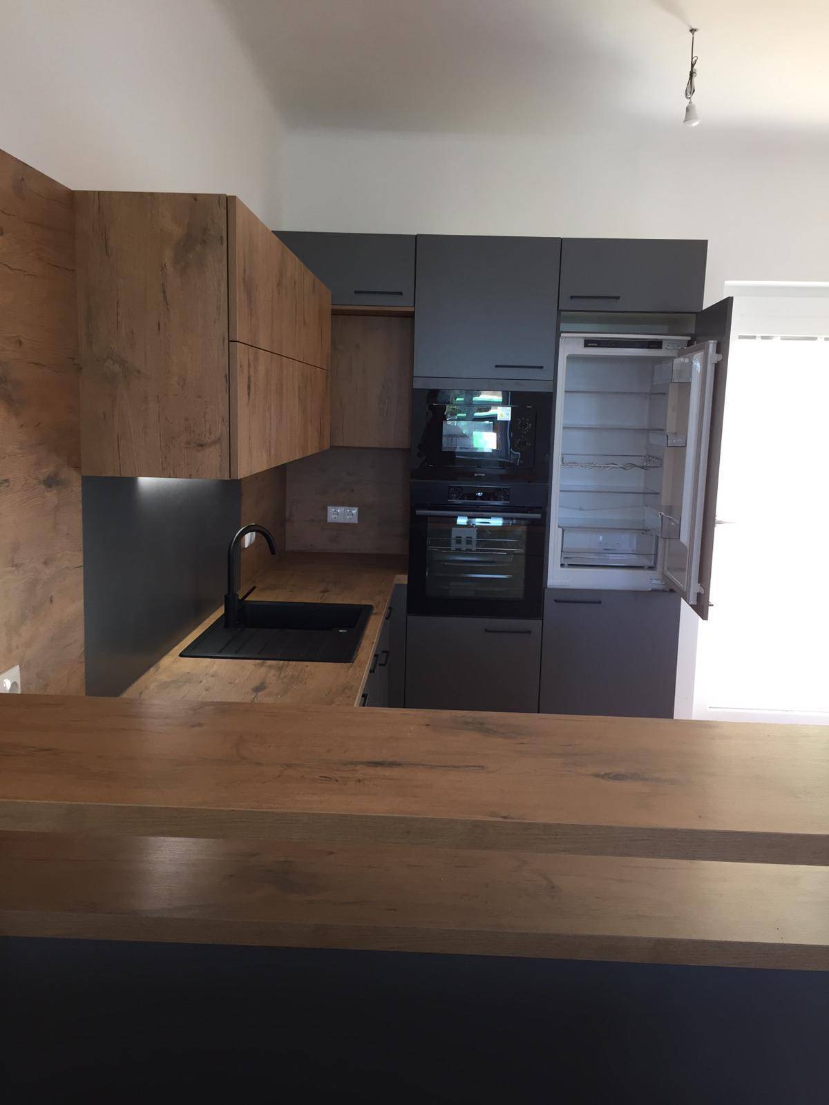Moderne Einbauküche mit integriertem Kühlschrank, Backofen und Mikrowelle.