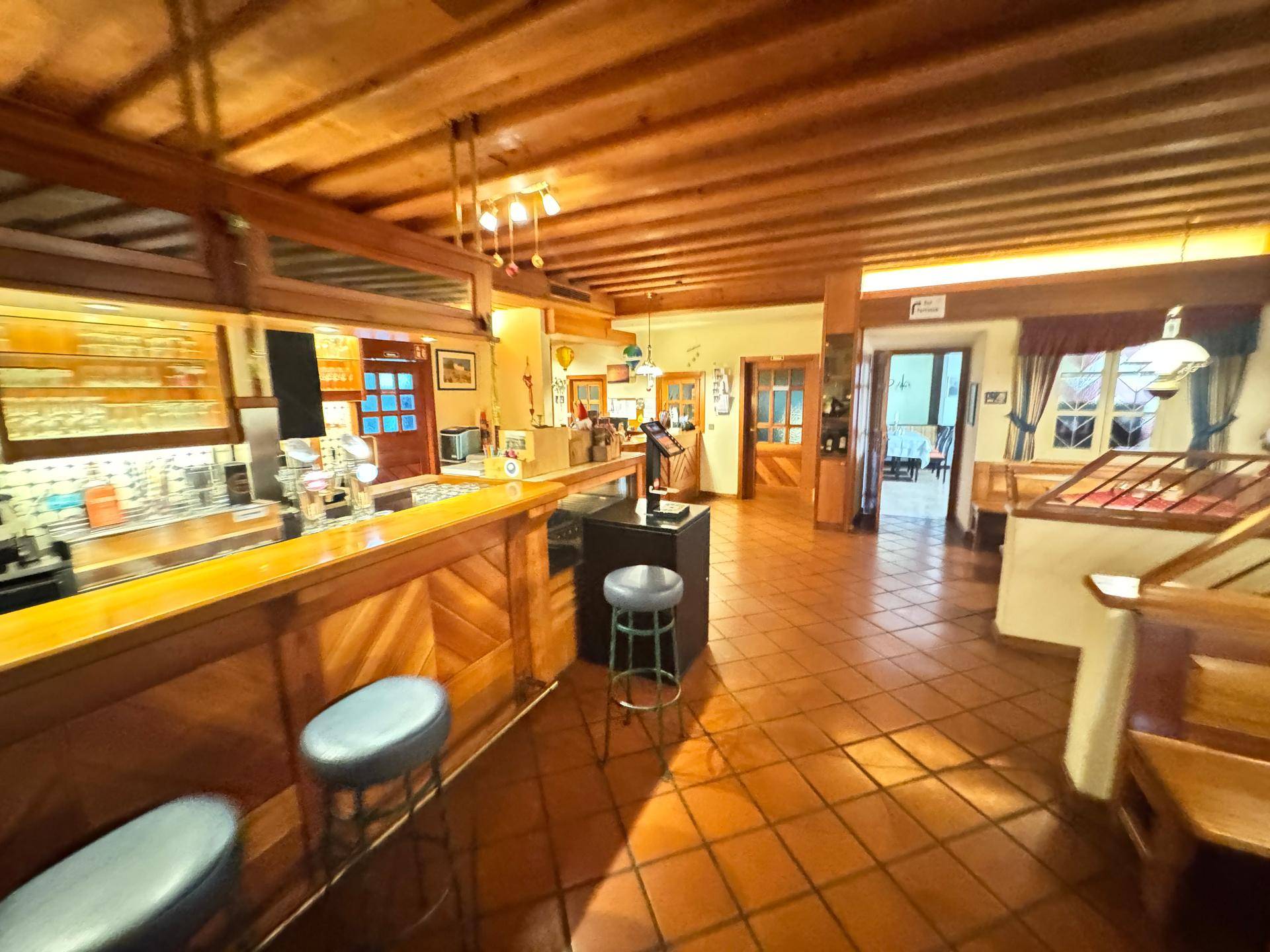 Rustikale Bar mit Holzelementen und gefliestem Boden.