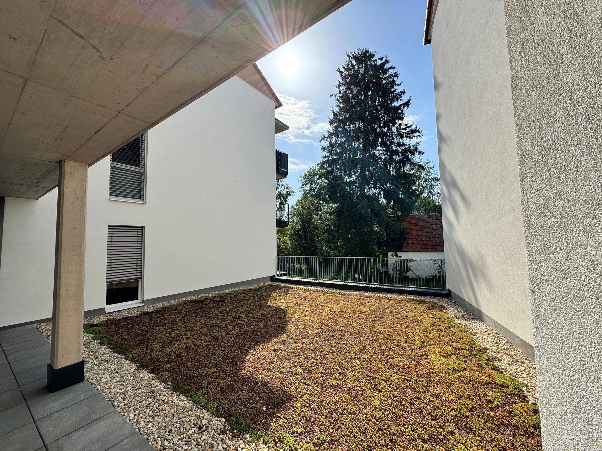Grüne Dachterrasse oder Gartenbereich mit Sedumbepflanzung und Kiesflächen.