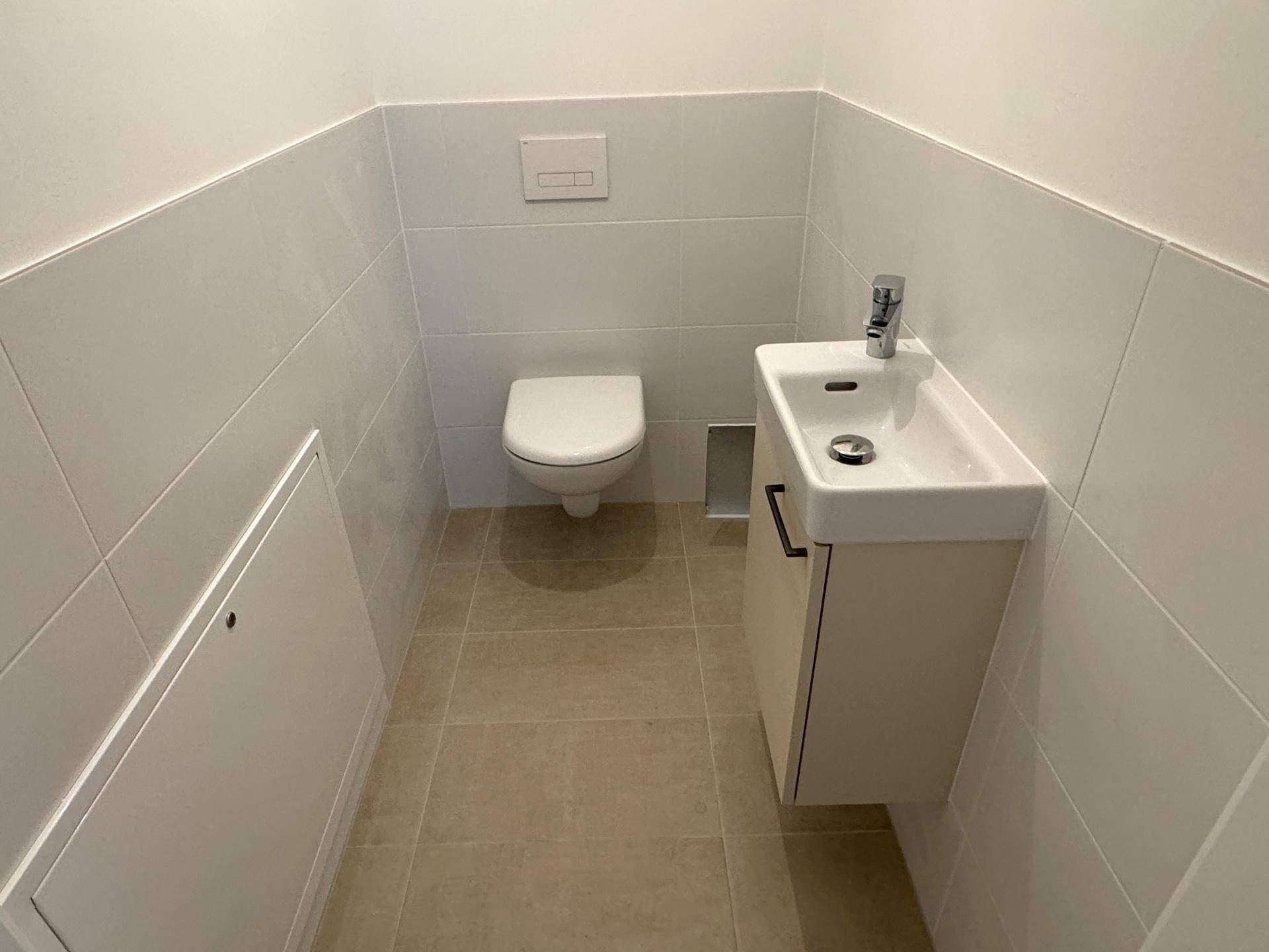 Kleines Gäste-WC mit wandhängender Toilette und modernem Waschbecken.