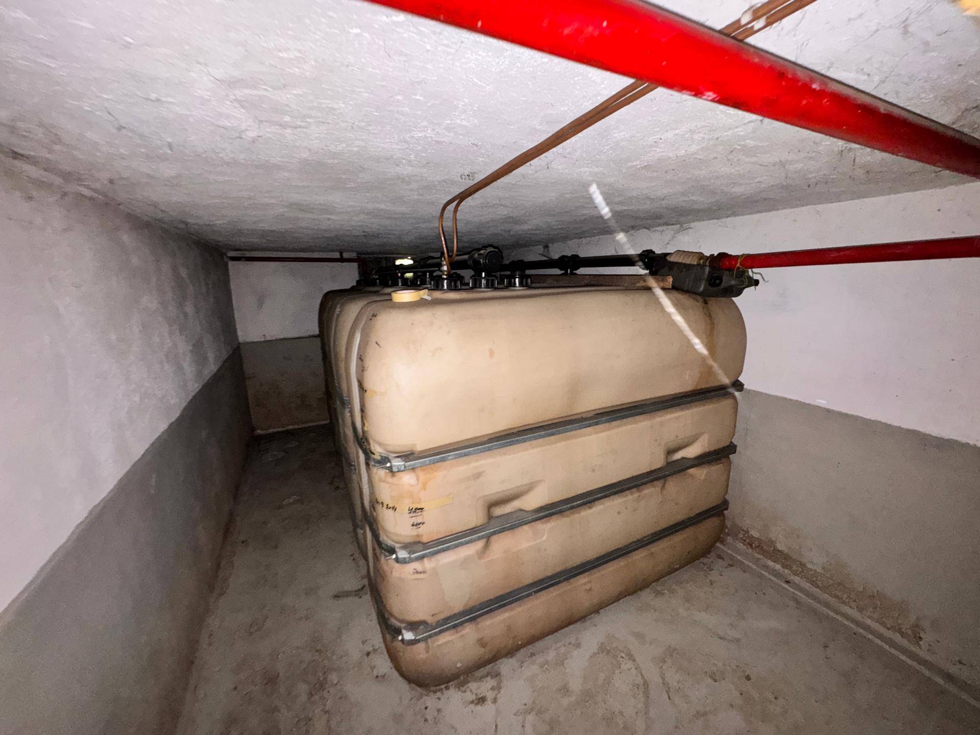 Kleiner Kellerraum mit Heizöltanks und sichtbaren Rohrleitungen an der Decke.