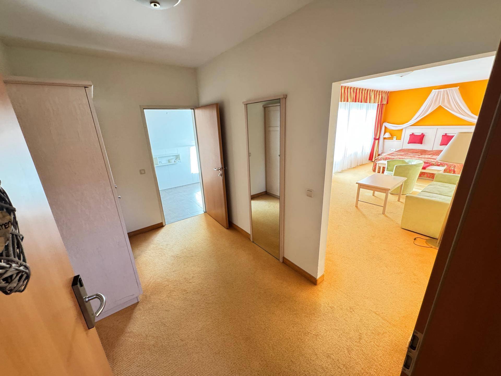 Flur mit Teppichboden und Zugang zu einem Schlafzimmer.
