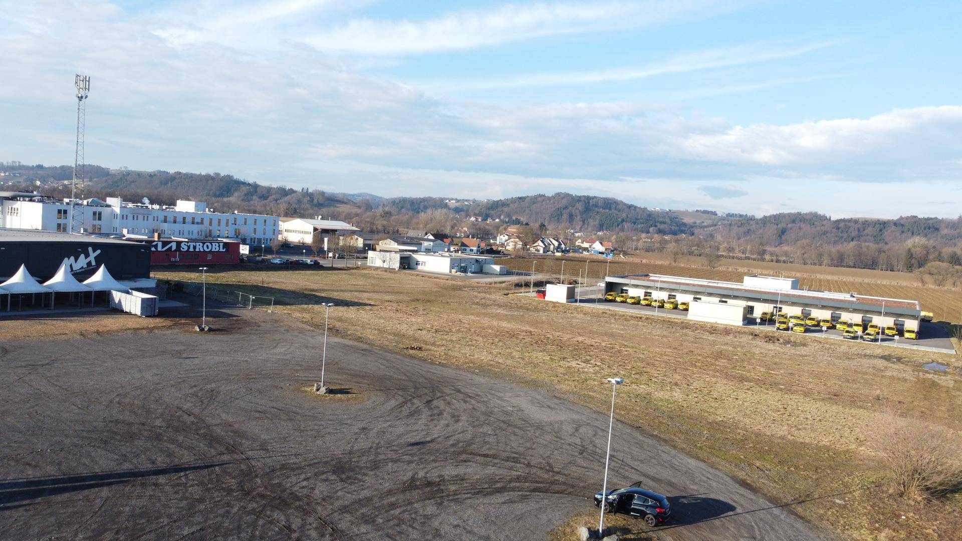 Panoramische Luftaufnahme eines weitläufigen Grundstücks mit Gewerbebauten und ländlicher Umgebung.