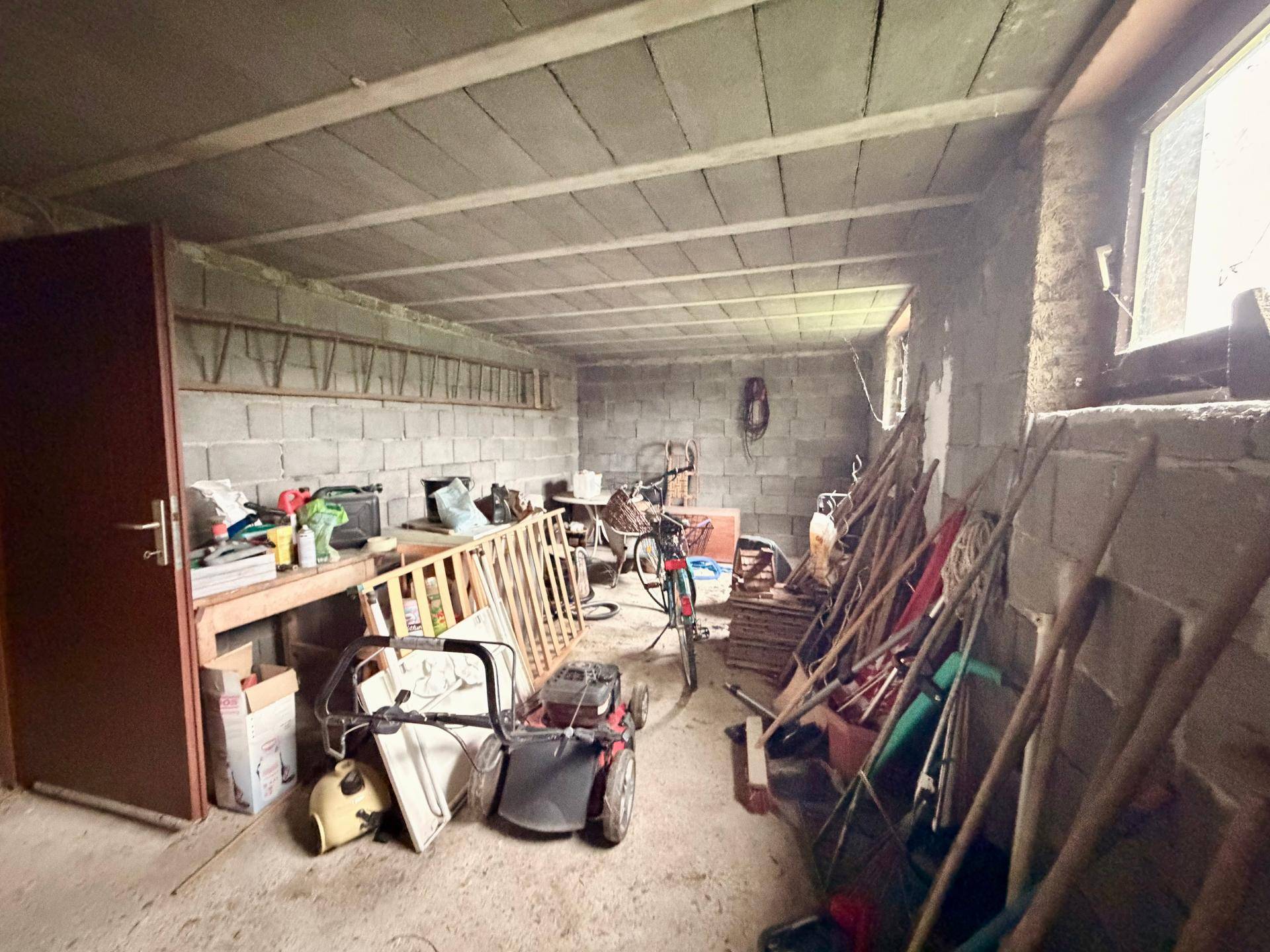 Unausgebauter Kellerraum mit Betonwänden und -decke, bietet viel Stauraum und Entwicklungspotenzial.