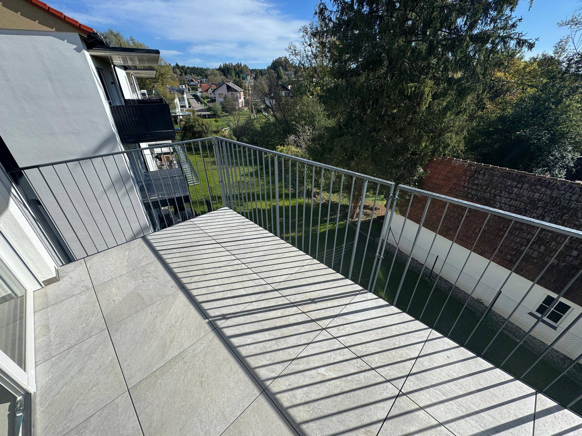 Gepflegte Rasenfläche vor den modernen Wohngebäuden mit Balkonen.