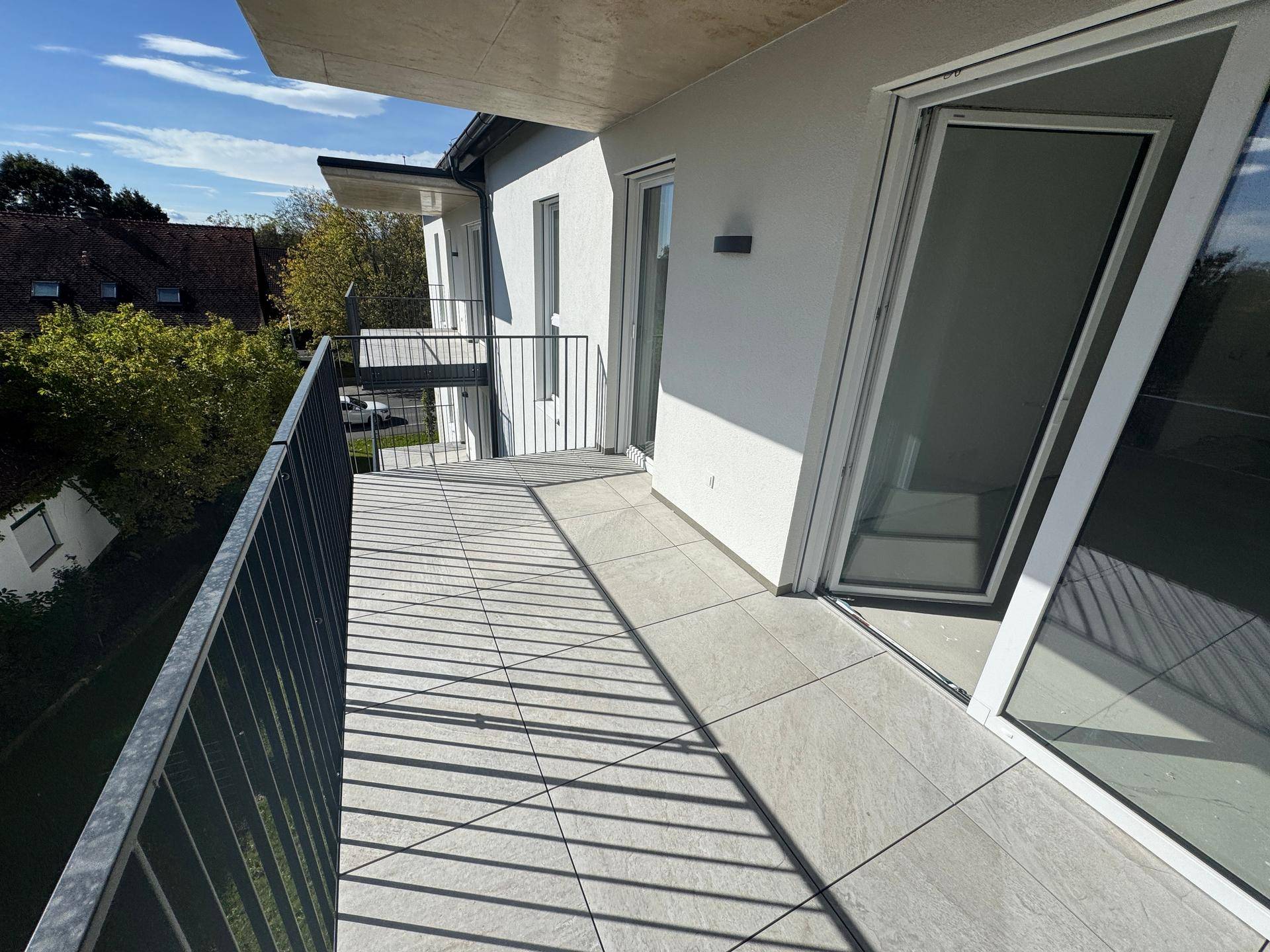 Balkon mit Blick auf die umliegenden Häuser und die grüne Landschaft.