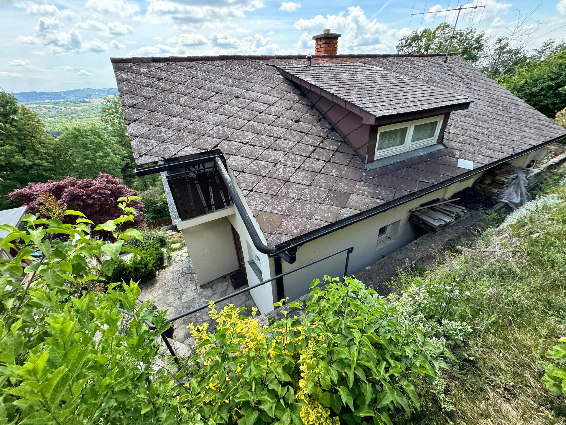 Dachansicht des Hauses mit Satteldach und umgebender Natur, bietet einen Blick in die Ferne.