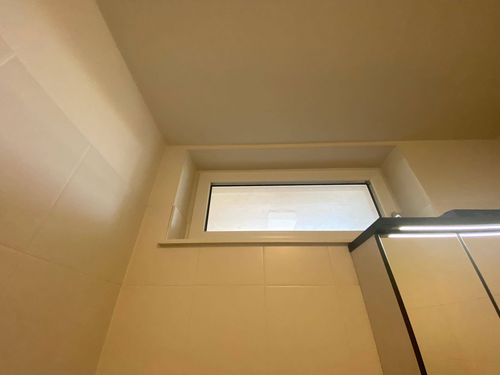 Kleines Fenster im Badezimmer sorgt für natürliche Belüftung und Licht.