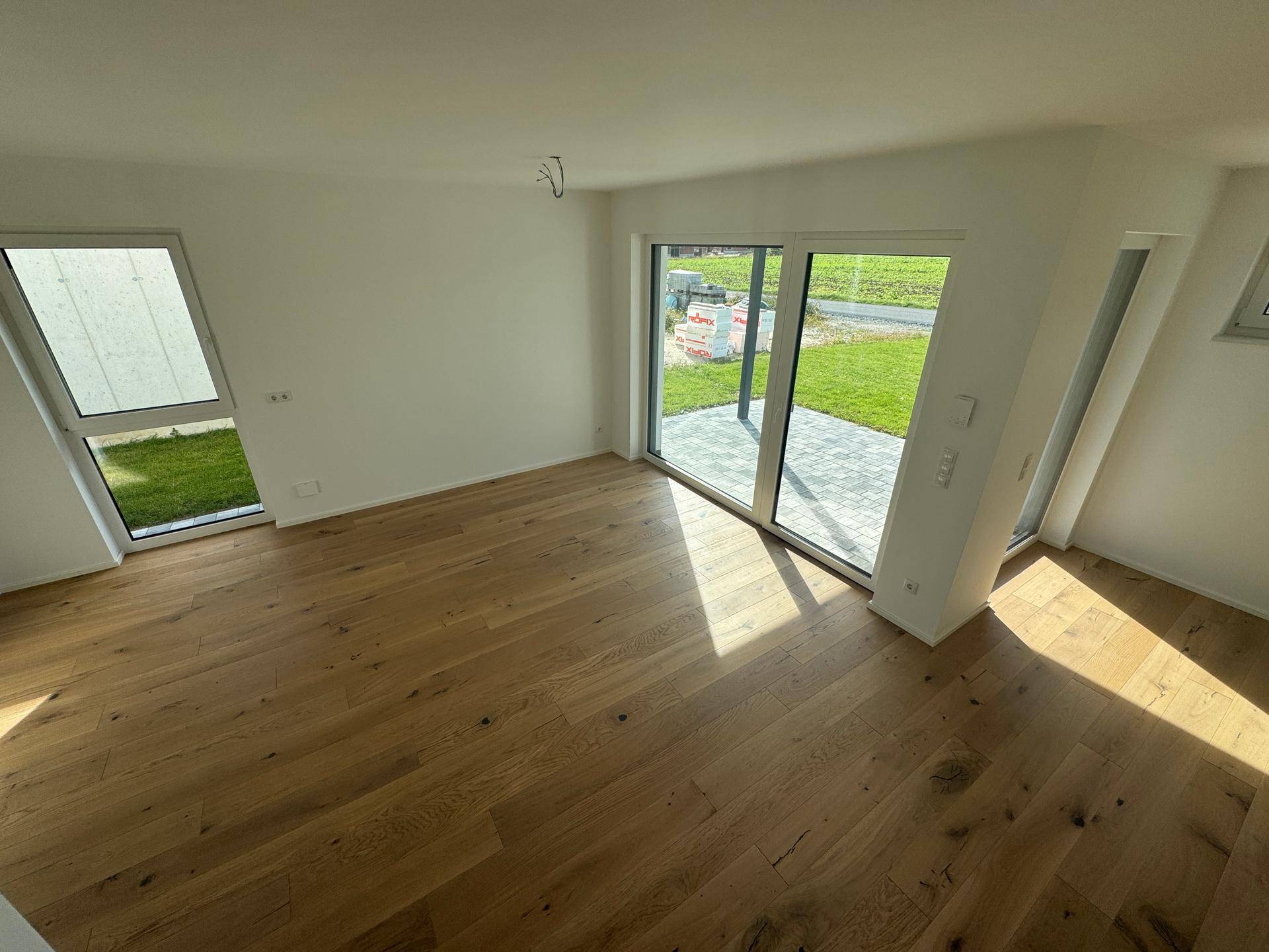 Helles Wohnzimmer mit Eichenparkett und großzügigem Zugang zur Terrasse und Garten.