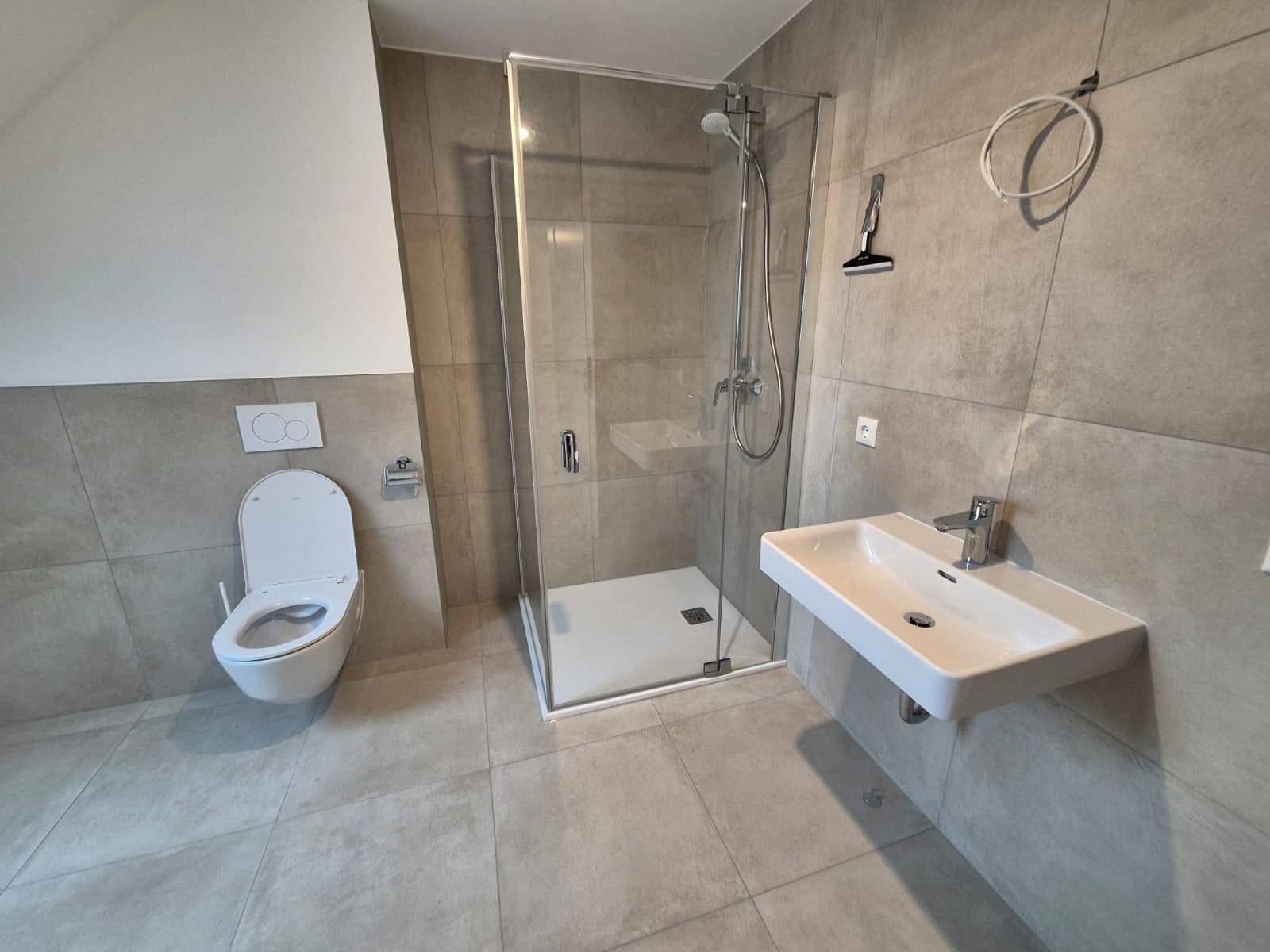 Modernes Badezimmer mit begehbarer Dusche, Wand-WC und schwebendem Waschbecken.