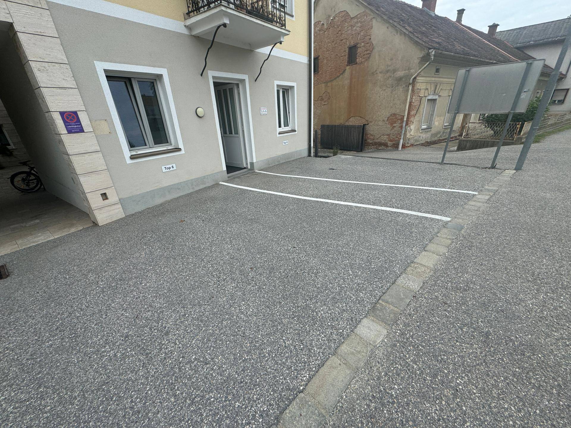 Außenansicht mit Parkplätzen und dem Eingangsbereich des Gebäudes, sauber und zugänglich.