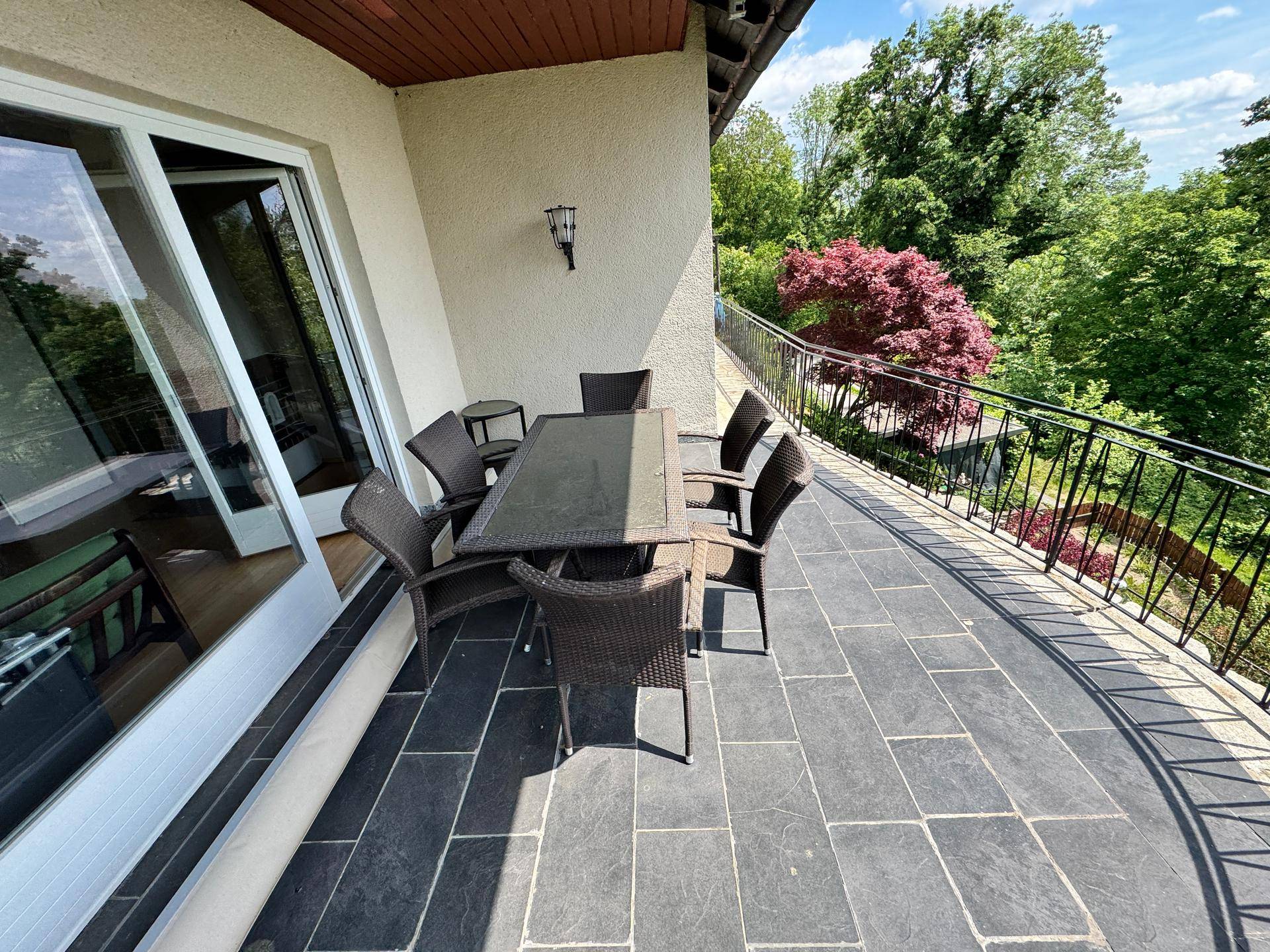 Geräumiger Balkon mit Esstisch und Stühlen, bietet einen weiten Blick über die Landschaft.