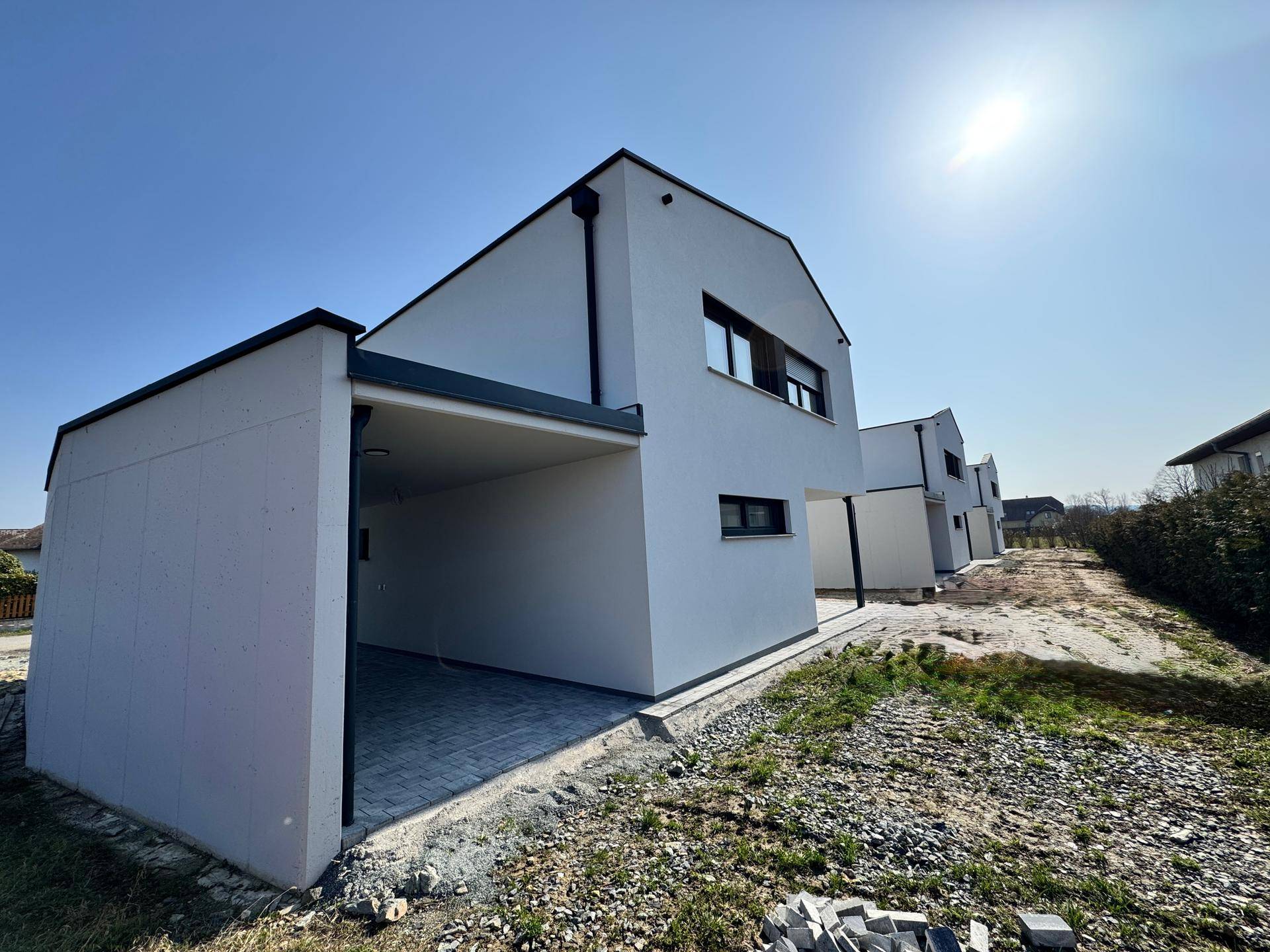 Moderne Doppelhaushälfte mit Carport und angrenzendem Gartenbereich in sonniger Lage.