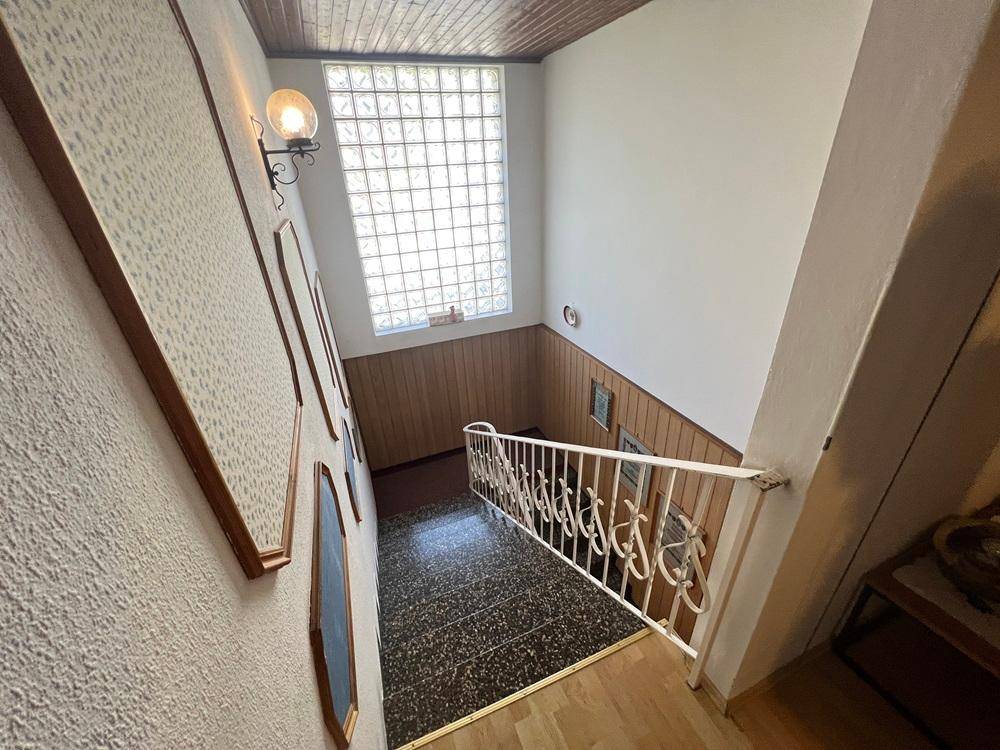 Helles Treppenhaus mit Glasbausteinfenster, das für natürliches Tageslicht sorgt.