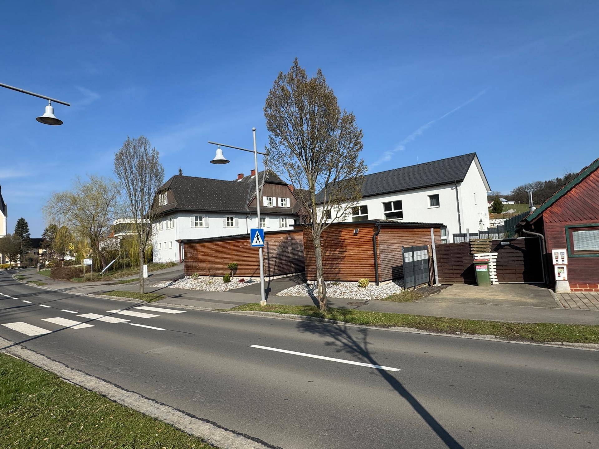 Straßenansicht mit modernen Laternen und weiteren Gebäuden in einer ruhigen Wohngegend.